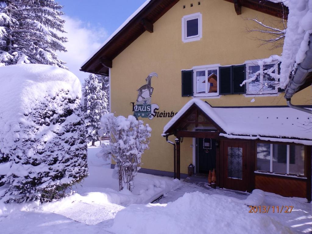 ein schneebedecktes Gebäude mit einem Schild darauf in der Unterkunft Apartments Haus Steinbock in Tauplitz