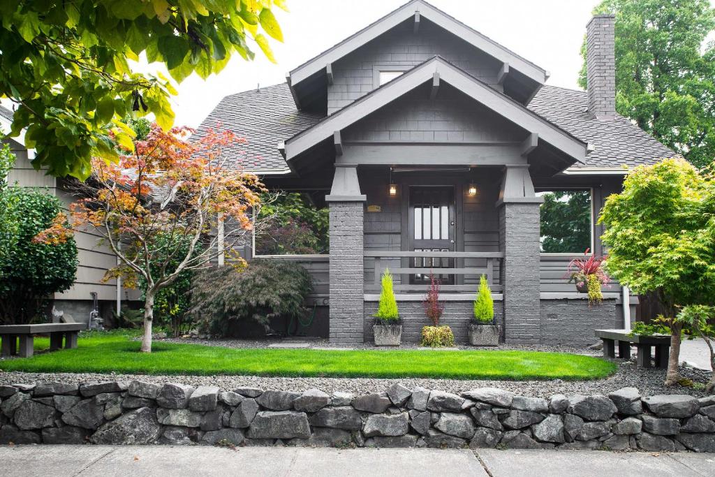 a house with a stone retaining wall in front of it at Updated Tacoma Home with Patio 3 Mi to Downtown in Tacoma