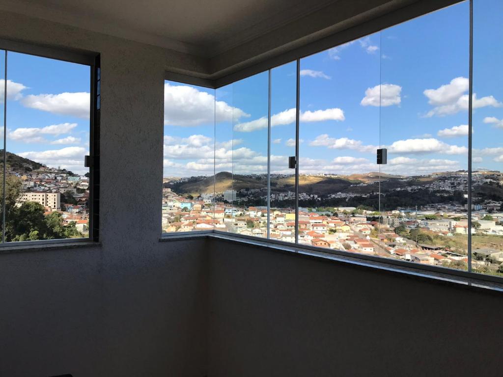 a room with windows with a view of a city at Apto 3 quartos com espaço gourmet e vista Panorâmica in Poços de Caldas