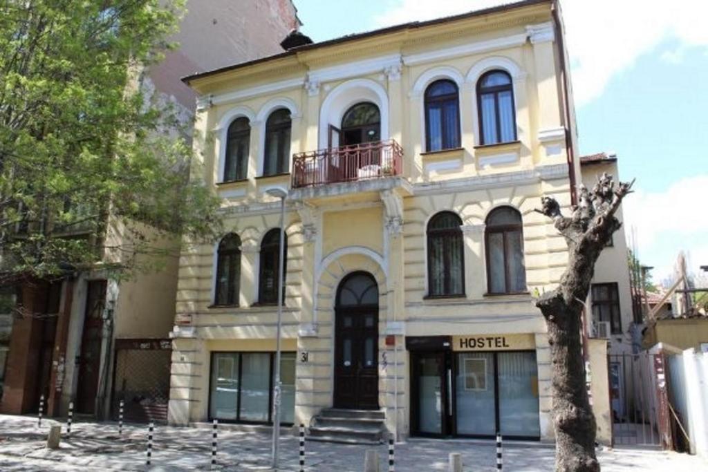 ein großes gelbes Gebäude mit Balkon in der Unterkunft Smart Hostel Sofia in Sofia