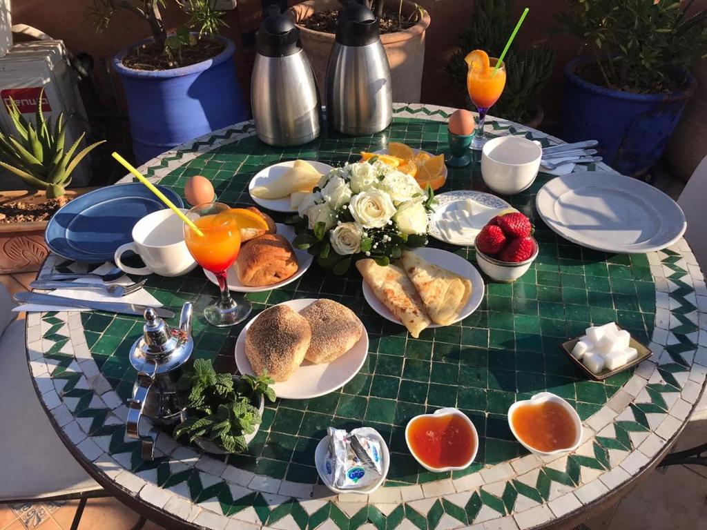 una mesa con platos de comida en la parte superior en Riad Johnboy, en Marrakech