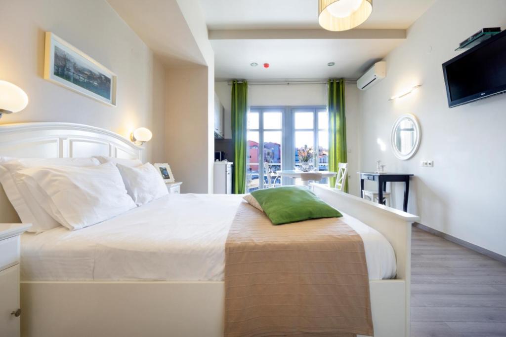 a bedroom with a large white bed with a green pillow at Casa Del Porto in Chania