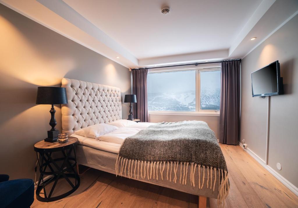 a bedroom with a large bed and a window at Ustedalen Hotel Geilo in Geilo