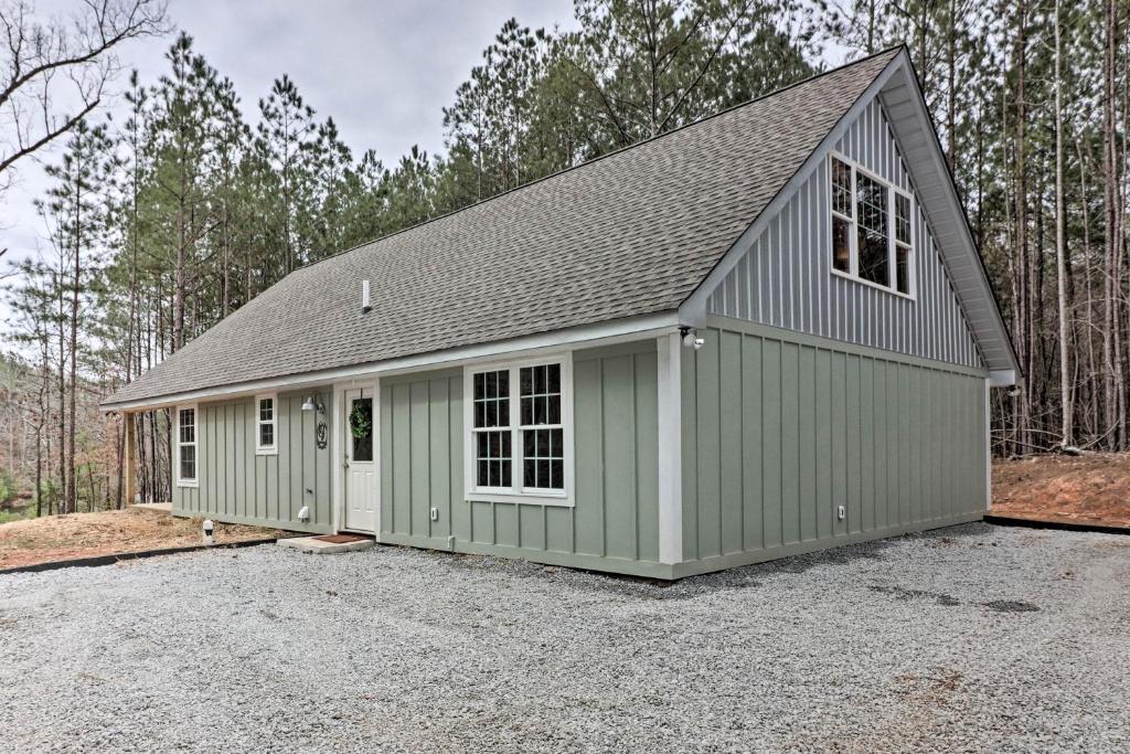 eine grüne Garage mit grauem Dach in der Unterkunft Peaceful Family Cabin on 10 Acres with Game Room! in Heflin
