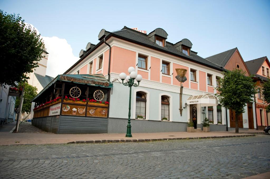 un bâtiment situé sur le côté d'une rue dans l'établissement Hotel Club, à Kežmarok