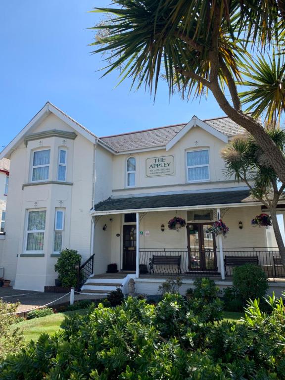 une maison blanche avec un palmier en face dans l'établissement Appley Lodge, à Shanklin