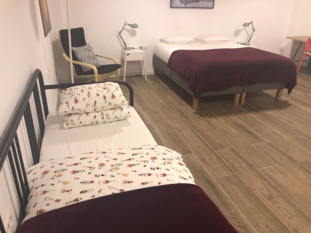 two beds in a room with wooden floors at Hassan Guesthouse in Nazareth