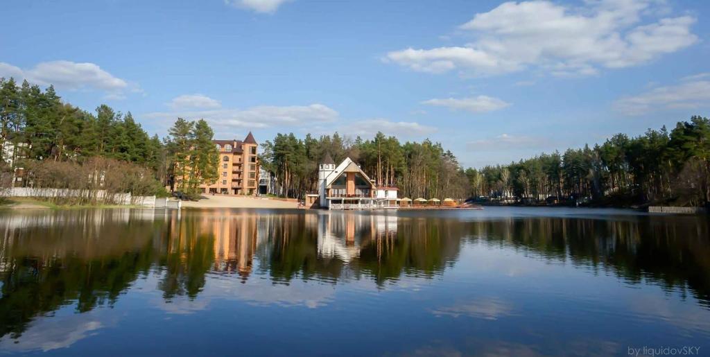 uma casa na margem de um grande lago em Заміський комплекс "Пуща Лісна" em Moshchun
