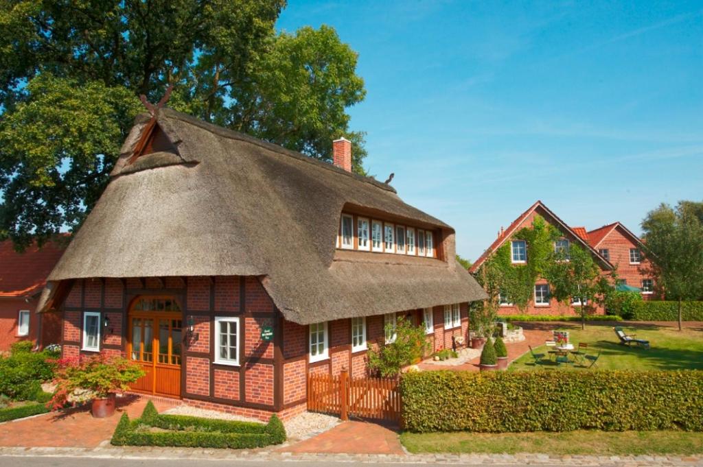 a small house with a thatched roof at Ferienhof Hage in Hüde