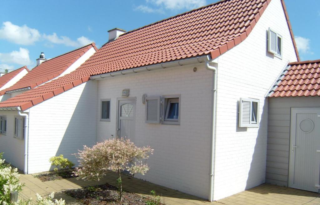 a row of houses with red roofs at Huisjes aan zee in De Haan