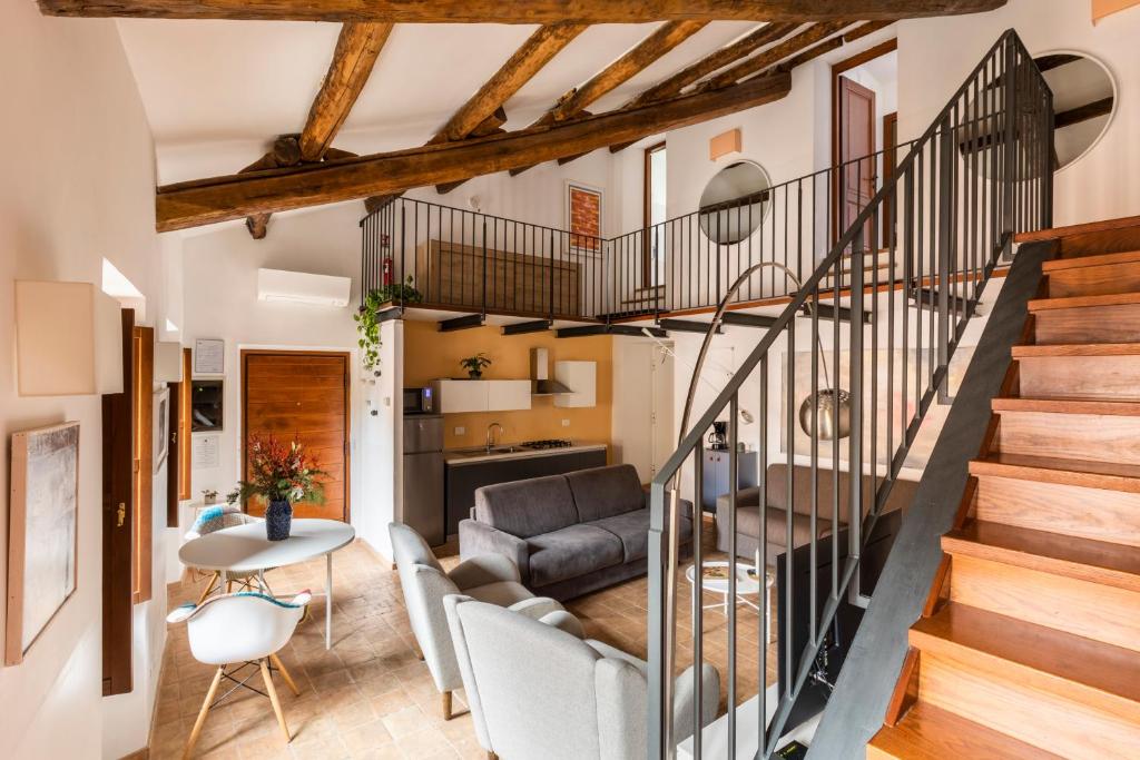 eine Treppe in einem Wohnzimmer mit Sofa und Tisch in der Unterkunft Experience Collection by ROMAC - Margana Palace in Rom