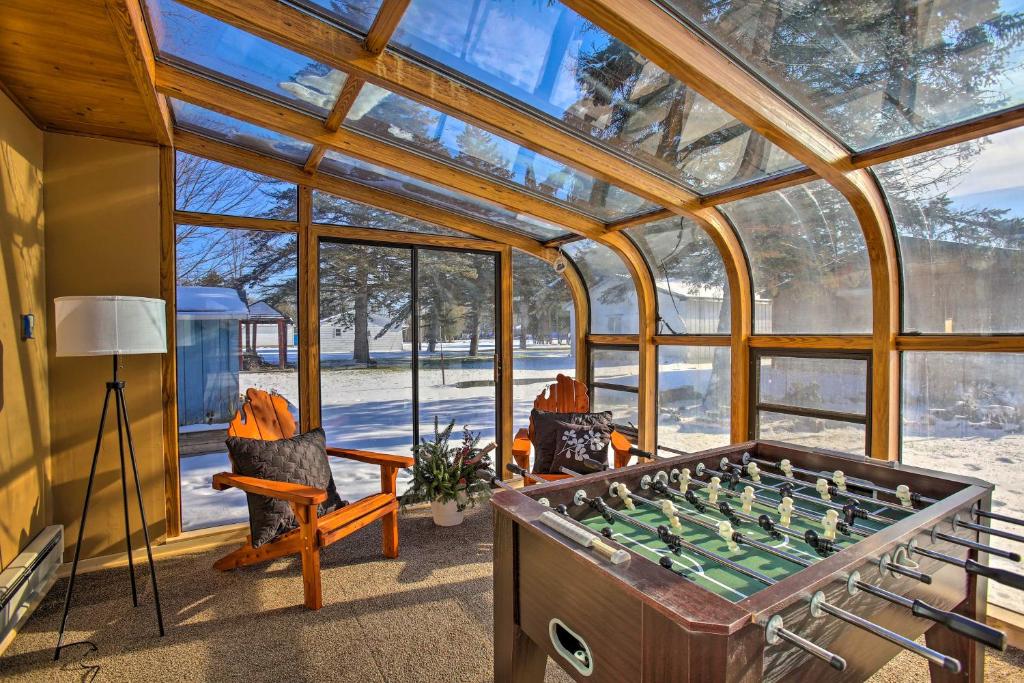 a room with a foosball table in a glass house at 4 Season, Waterfront Houghton Lake House with Dock! in Houghton Lake
