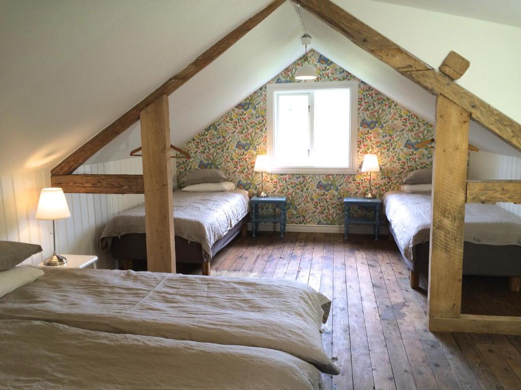 a attic bedroom with two beds and a window at The Fork and Shovel Farm in Bräcke