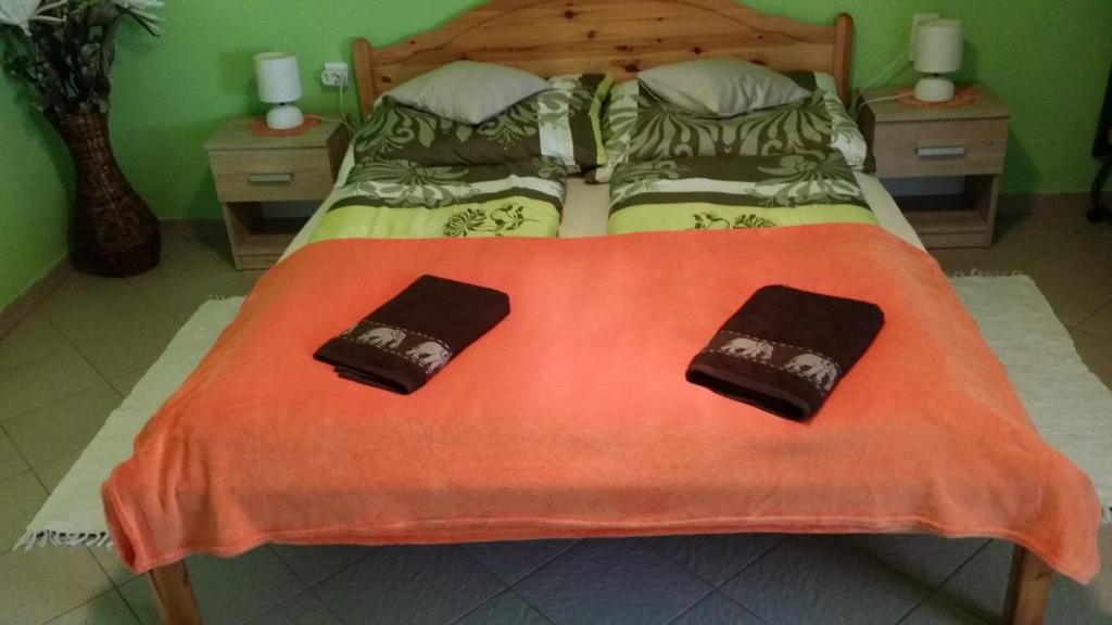 een slaapkamer met een bed met 2 kussens erop bij Zeg-zug Vendégház in Nemesdéd