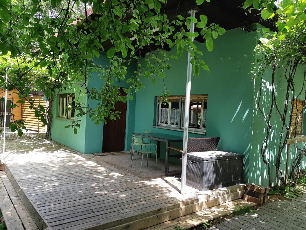 Casa verde con mesa y ventana en Ferienhaus zum Berg, en Neuhaus an der Pegnitz