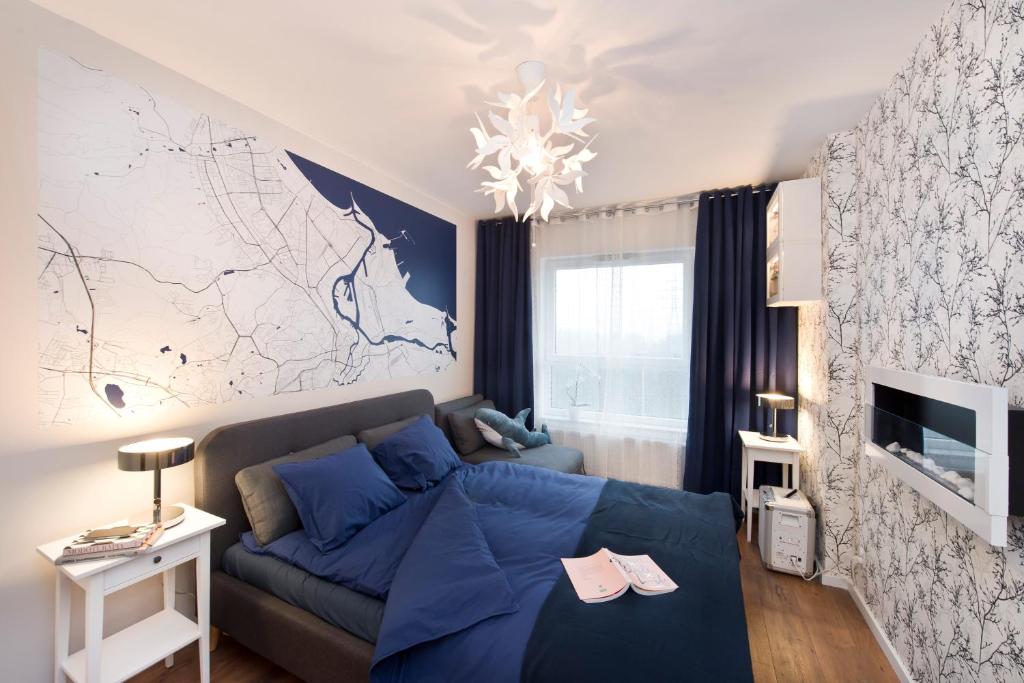 a living room with a blue couch and a map on the wall at Love In Gdańsk AON Apartments in Gdańsk