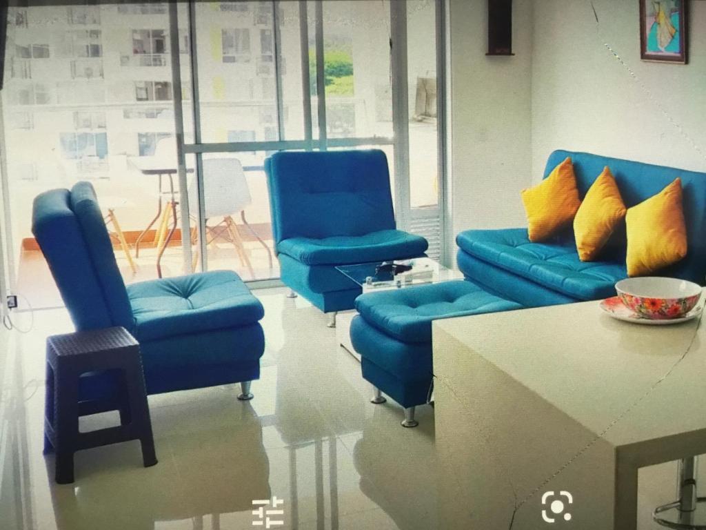 a room with three blue chairs and a table at Condominio peñazul la morada lo mejor in Girardot