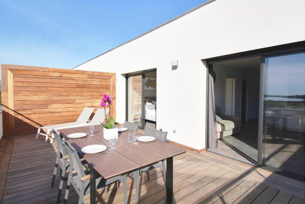 a wooden deck with a wooden table and chairs at Residence ACQUA LINDA Porticcio in Porticcio
