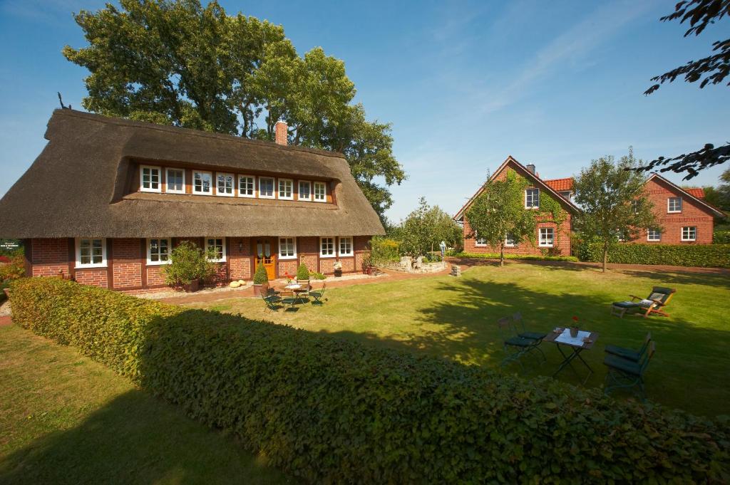 une maison avec un toit de chaume et une cour dans l'établissement Ferienhof Hage, à Hüde