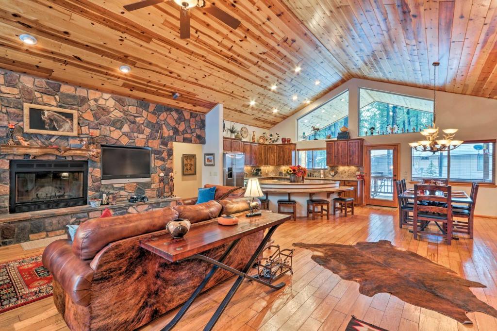 uma sala de estar com um sofá de couro e uma parede de pedra em Luxe Cabin with Deck Less Than 3 Mi to Pinetop Country Club em Indian Pine