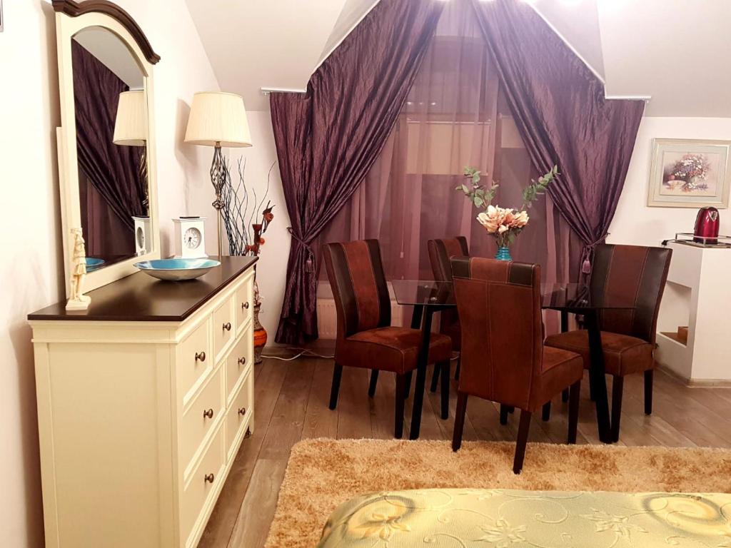 a dining room with a table and a mirror at Apartament Fluturaș de Stâncă Comarnic in Comarnic