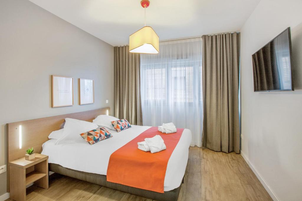una camera d'albergo con letto e finestra di Appart'City Classic Annemasse Centre - Pays de Genève ad Annemasse