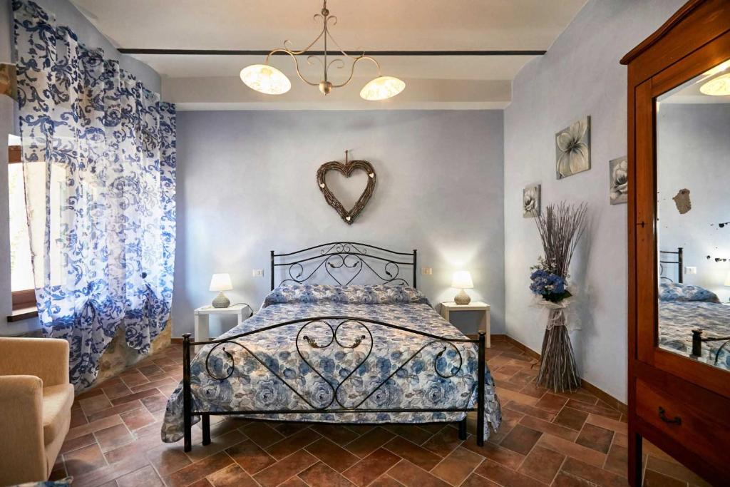 una camera da letto con letto e tende bianche e blu di Agriturismo MonteCrespini a Saturnia
