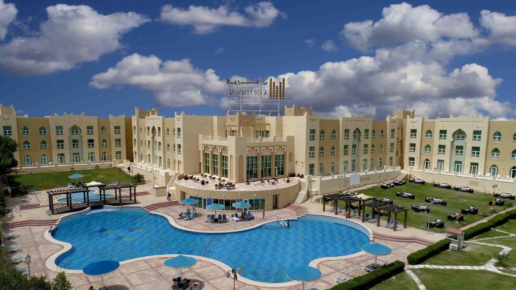 a resort with a large pool in front of a building at Copthorne Al Jahra Hotel & Resort in Kuwait