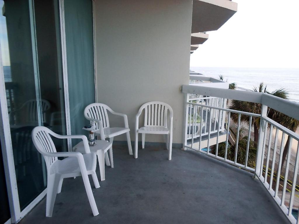 two chairs and a table on a balcony with the ocean at 0308 Waters Edge Resort condo in Myrtle Beach