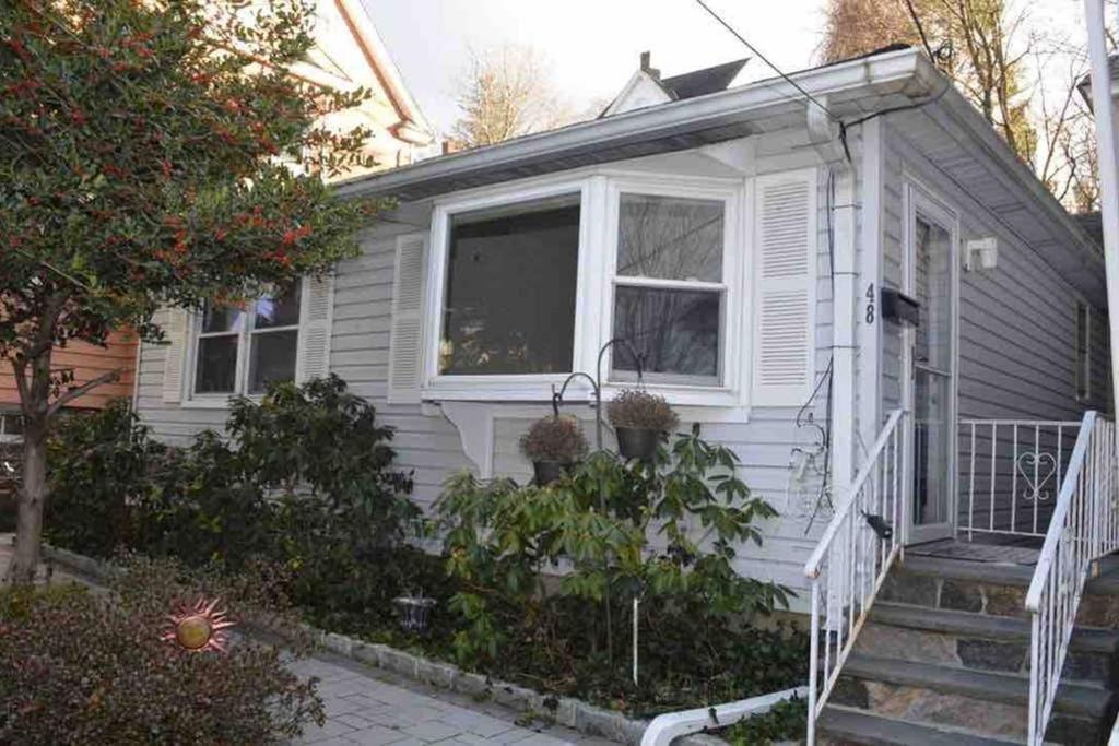 Casa blanca pequeña con escaleras y ventana en La Casita Bonita Near NYC, en Yonkers