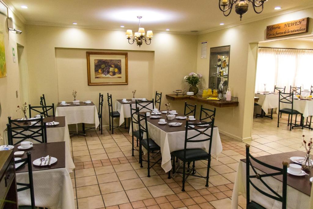 a restaurant with tables and chairs in a room at Hotel Don Eduardo in Temuco