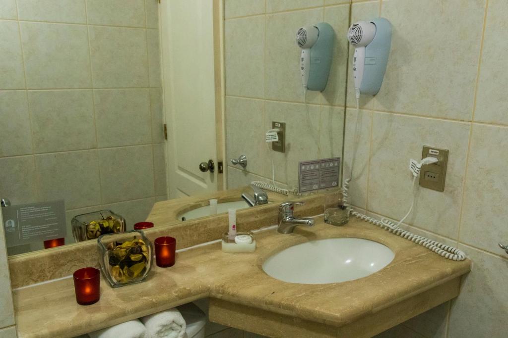 a bathroom with a sink and a mirror at Hotel Don Eduardo in Temuco