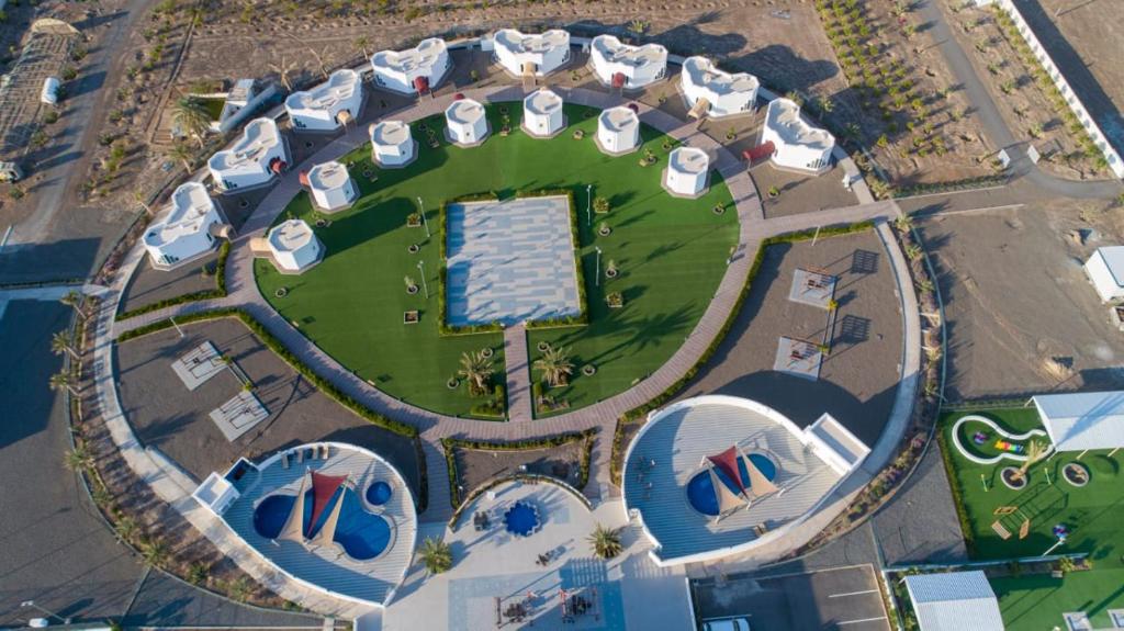 an overhead view of a park with buildings and a pool at SAJ Farm Inn in Ibrā