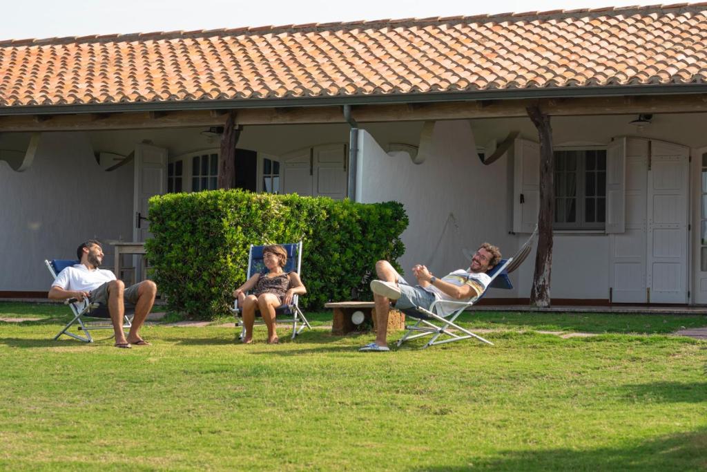 een groep mensen die in stoelen in een tuin zitten bij Residence Isola dei Mori in SantʼAntìoco