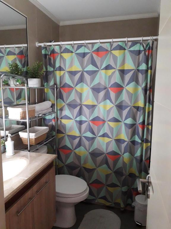 a bathroom with a shower curtain and a toilet at DEPARTAMENTO CENTRO TEMUCO in Temuco