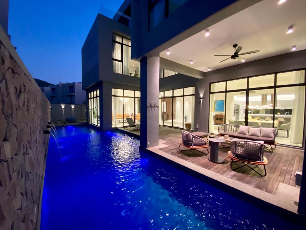 a house with a swimming pool in front of a house at Molly Luxury Private Pool Bungalow茉莉的家豪华私人泳池别墅 in Pantai Cenang