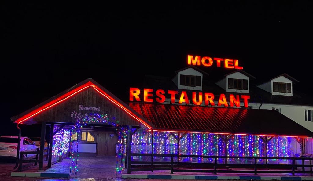 un restaurant de motel avec des lumières de Noël dans un bâtiment dans l'établissement Motel Valentina, à Ion Roată