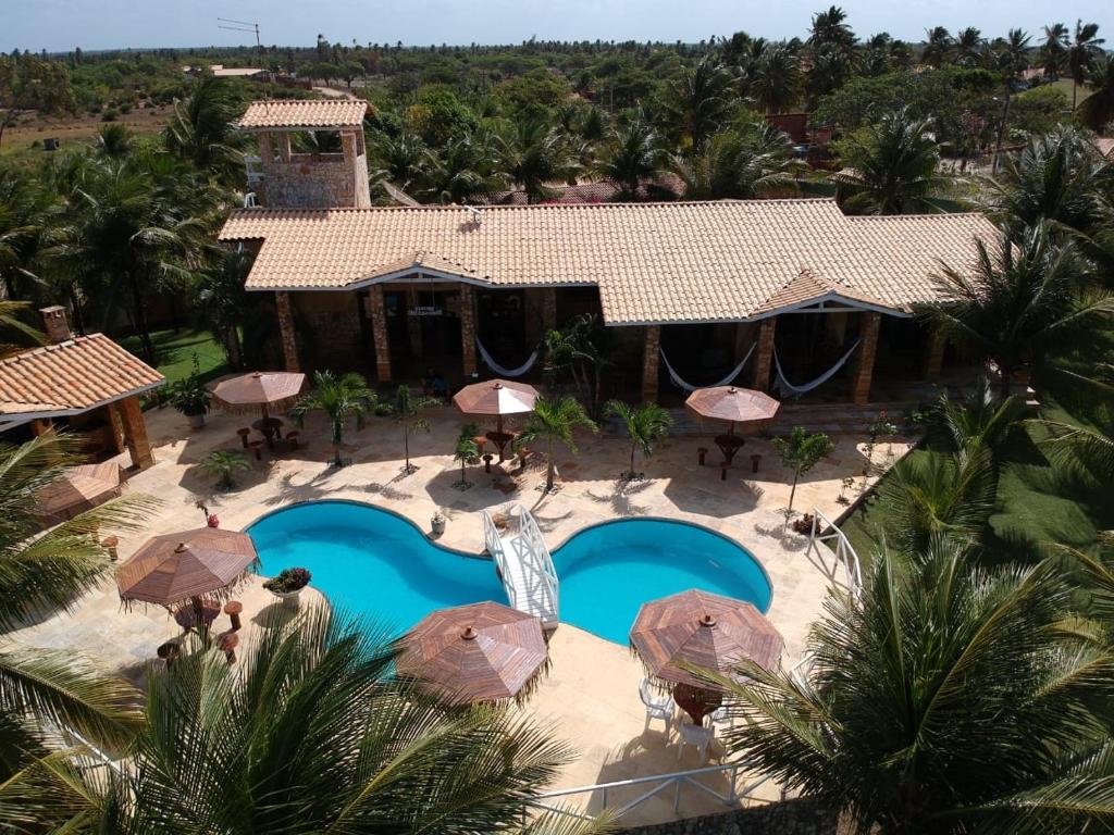 an aerial view of a resort with a pool and umbrellas at Castelo das Dunas Camping e MotorHome in Paracuru