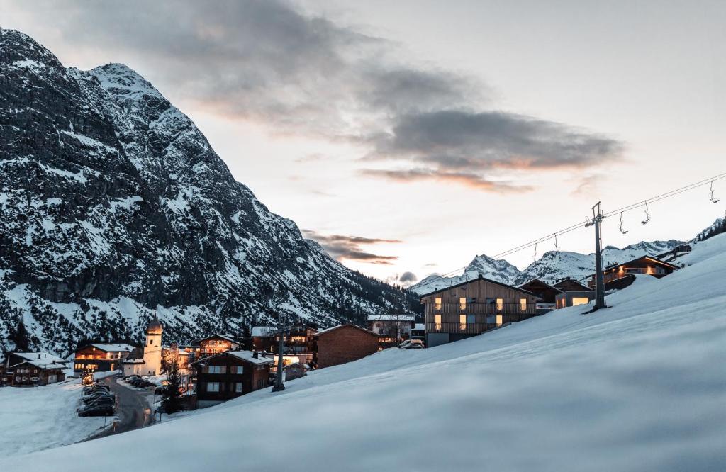 Eine Stadt im Schnee mit einem Berg in der Unterkunft Burgi's - Adults only in Lech am Arlberg