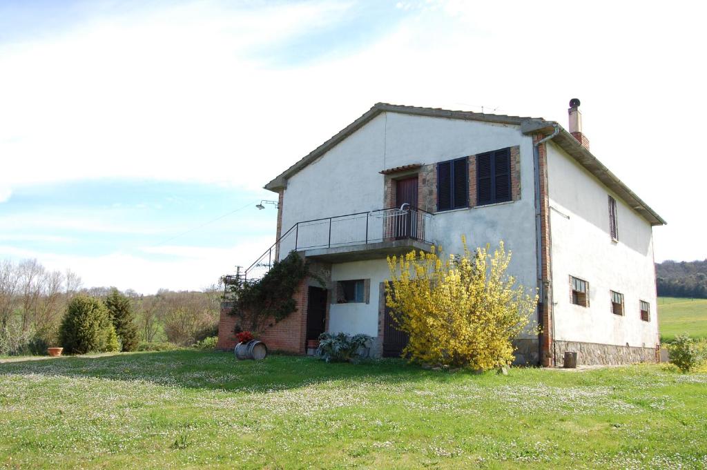 a white house with a balcony on the side of it at Agriturismo Rossello in San Quirico dʼOrcia