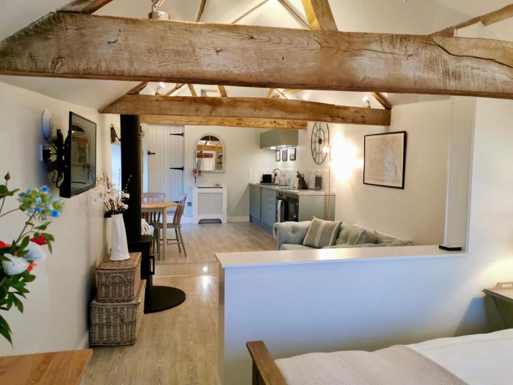 a living room and kitchen with wooden beams at The Stables in Monmouth