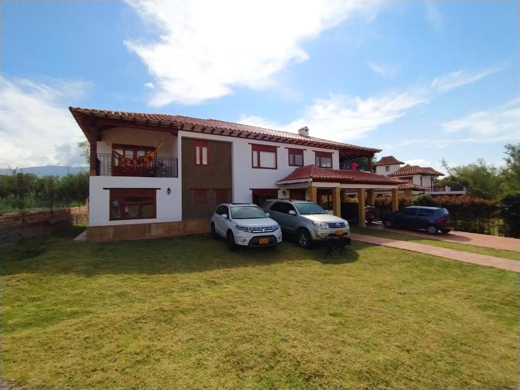ein Haus mit zwei Autos, die davor geparkt sind in der Unterkunft Villa Fortuna in Villa de Leyva