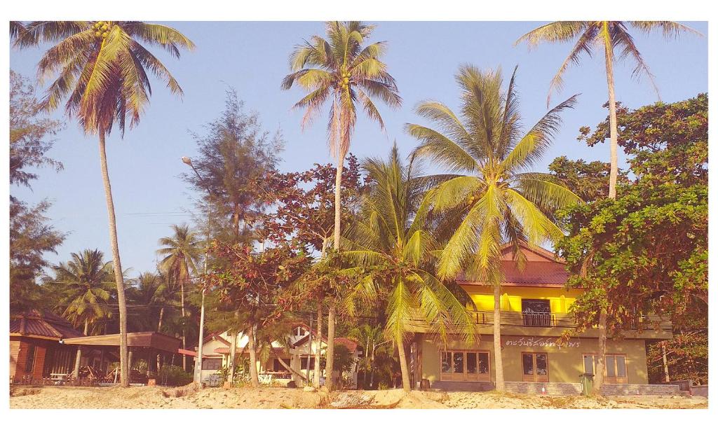 a house with palm trees in front of it at TAWAN RESORT in Chumphon