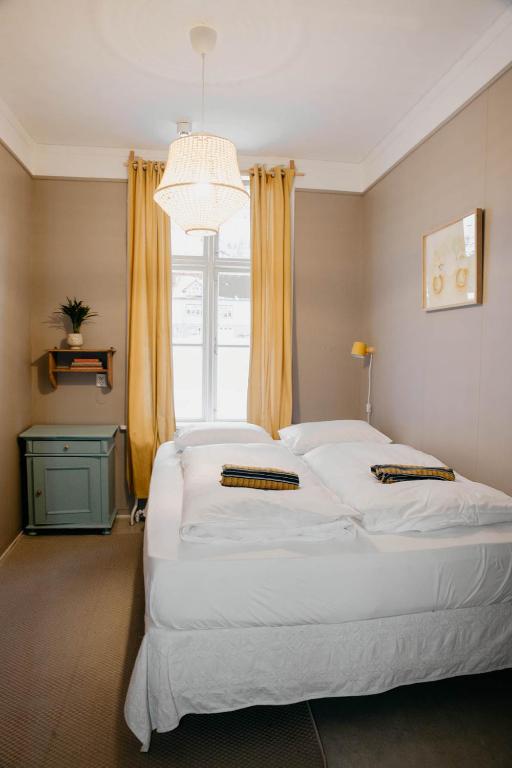 a bedroom with a large white bed with a window at Hafaldan HI hostel, old hospital building in Seyðisfjörður