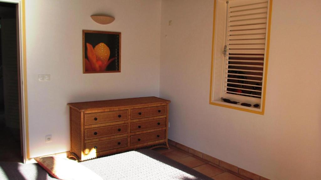 1 dormitorio con tocador de madera y ventana en Anse Figuier Gites de France, en Terre-de-Haut