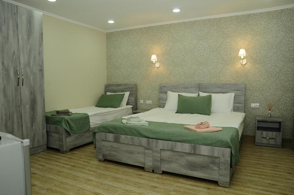 a bedroom with two beds with green and white at Erik's Guest House in Borjomi