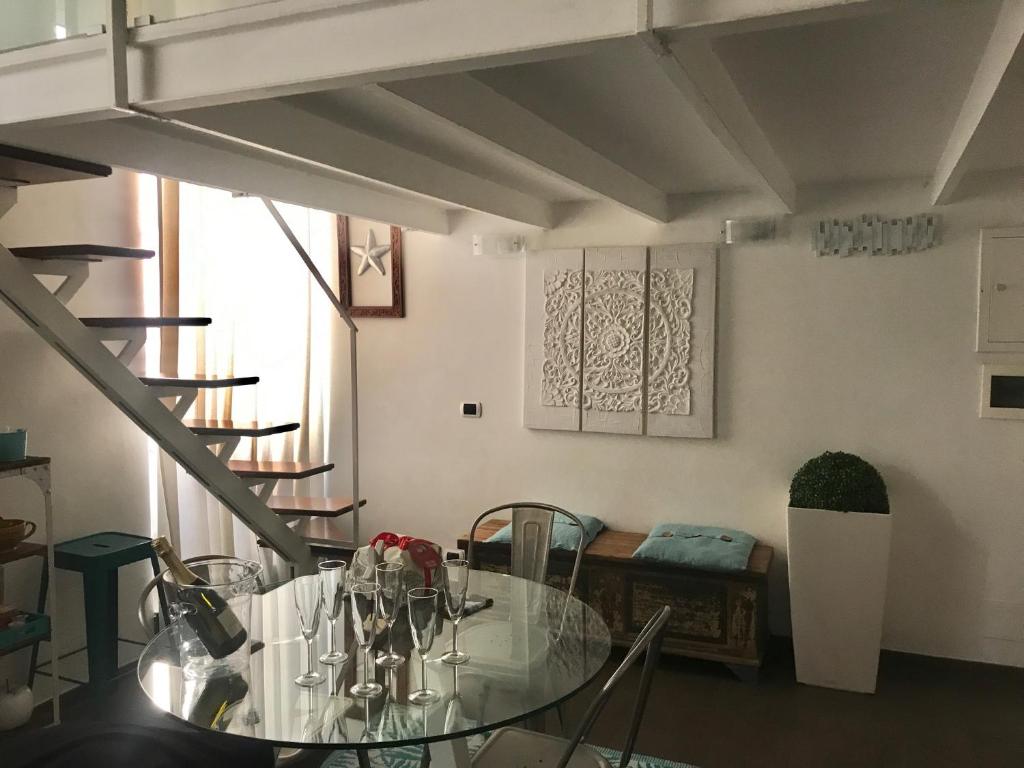 une salle à manger avec une table en verre et un escalier dans l'établissement Trastevere Star, à Rome