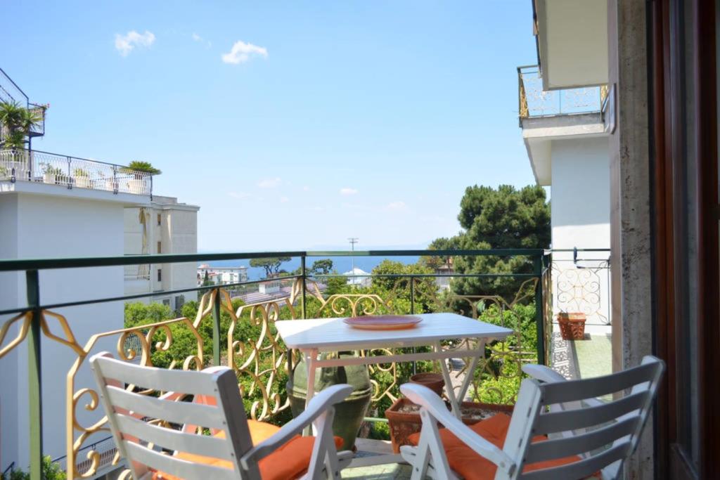 een tafel en stoelen op een balkon met uitzicht bij Bright 3 Bedrooms Apartment with Seaview Balcony in Sorrento