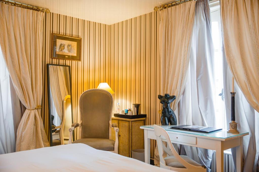 a bedroom with a bed and a desk and a window at Domaine Saint Clair - Le Donjon in Étretat