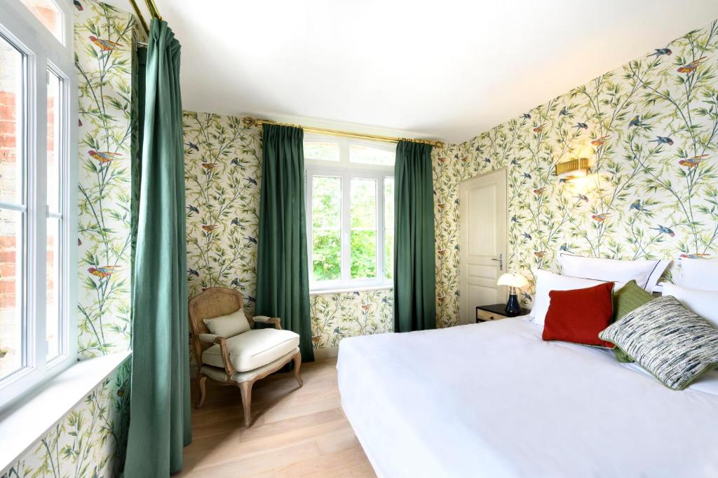 a bedroom with a large bed and green curtains at Domaine Saint Clair - Le Donjon in Étretat